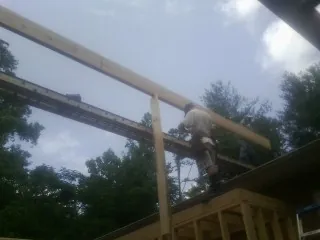 Carpenter setting a ridge beam over a new addition frame — Ice Dam Removal by Roofing Brothers in Belle Vernon