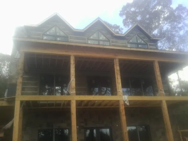 Dormers and porch framing on a large log home under construction — Roof Coating work by our crew in Belle Vernon